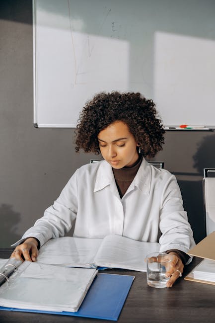 Professional woman carefully reviewing paperwork in modern office setting.