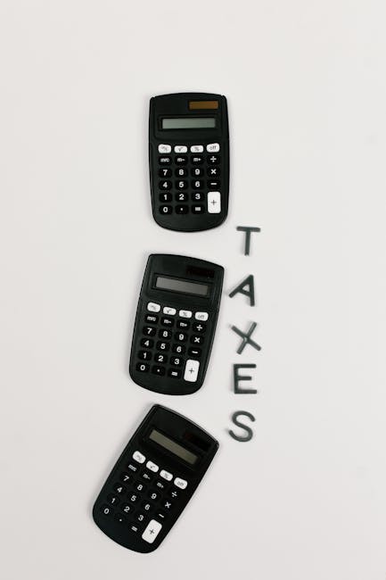 Flat lay of three calculators with 'TAXES' text on a white background.
